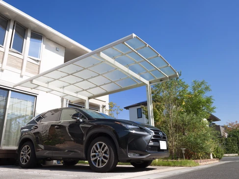 Scène extérieure résidentielle avec véhicule SUV noir stationné sous un carport moderne